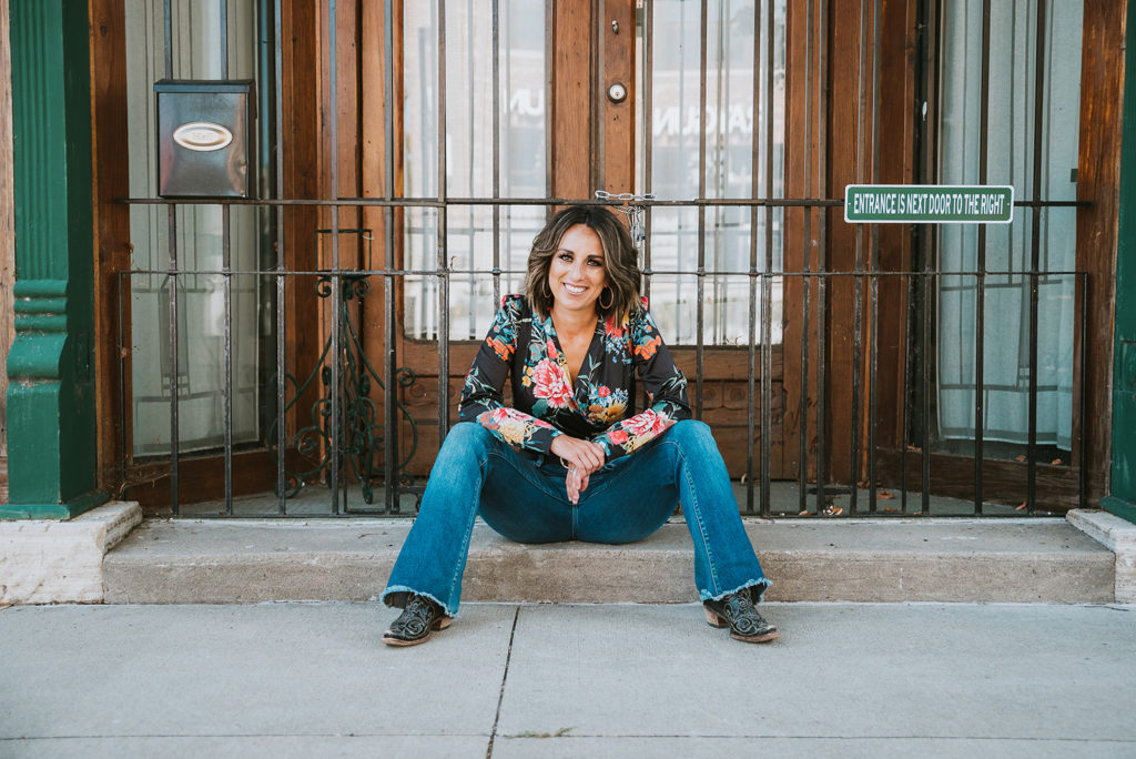 Queen Connection Founder, Katie Stien sitting cowboy boots pageants